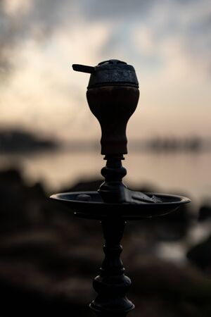 Top of hookah on nature. Sunset time and lake on backgroundの写真素材
