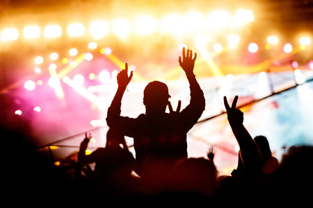 Girl enjoying a music festival or concert. Black silhouette of the crowd