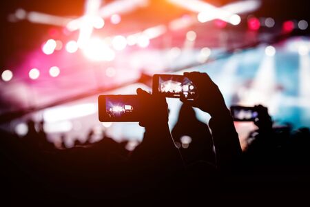 Hand with a smartphone shooting live music festival, concertの写真素材