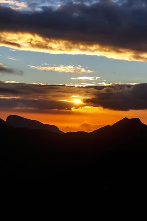 Sunset. The sun above the line of mountainsの写真素材