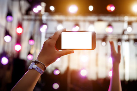Using smartphone at music show. Empty blank white screen for your image