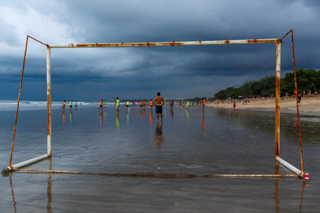 Kuta, Indonesia - March 26, 2019 : The soccer team trains on the beach after low tide. Dramatic...