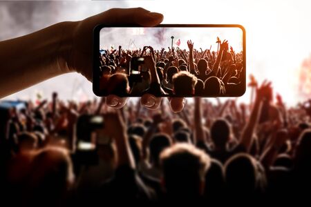 Using technology at the event. Mobile phone in hand.の写真素材