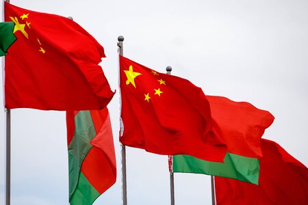 Belarusian and Chinese flags fluttering in the windの写真素材