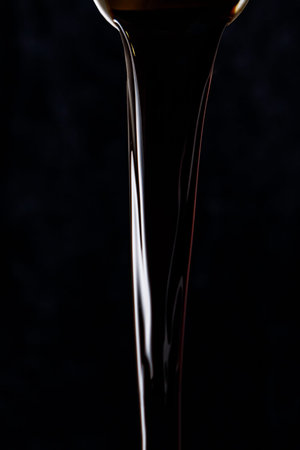 Black beer pouring on a black backgroundの写真素材