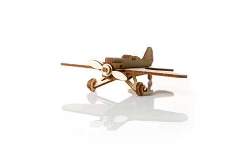 Small wooden airplane on a white background with reflectionの写真素材