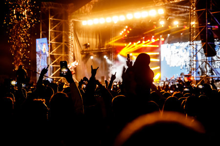 Crowd at a concert. Hands and smartphones in front of the stageの写真素材