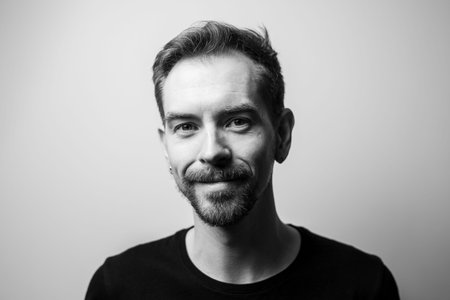 Portrait of smiling young man on gray background. Black and white