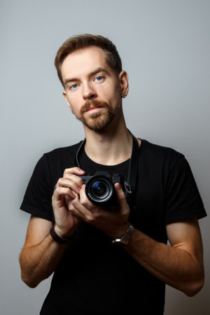 Portrait of a young photographer on a gray backgroundの写真素材