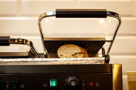 Sandwich toaster with toast and ingredients