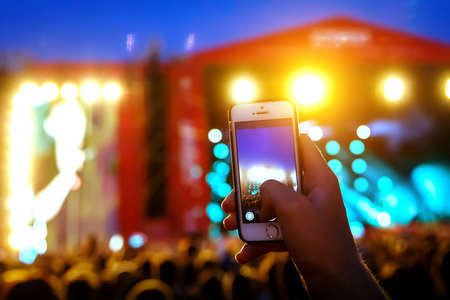 People holding their smart phones and photographing concertの写真素材