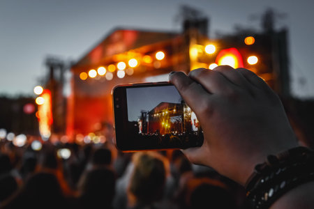 The smartphone in hands, shooting the concert stageの写真素材