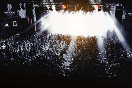 Silhouette of man with raised hands on music concert.の写真素材
