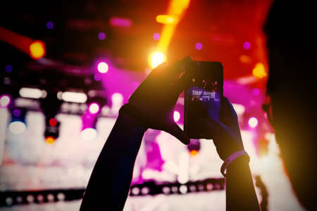 The smartphone in hands, shooting the concert stageの写真素材