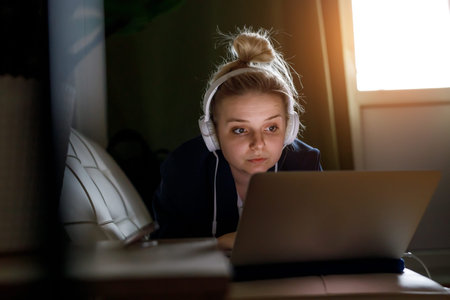 Young woman working on laptop computer while sitting at the living roomの写真素材