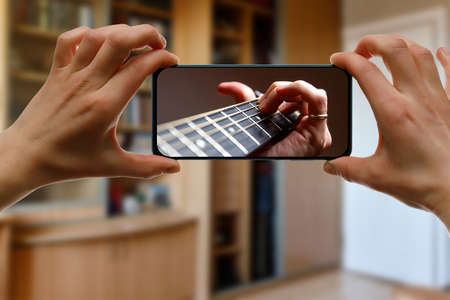Online guitar lesson via smartphoneの写真素材