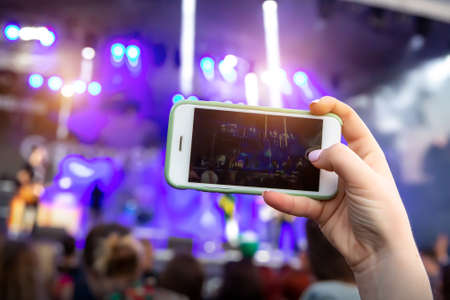 Concert visitor shoots video on a smartphoneの写真素材