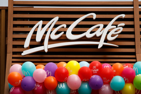 McCafe and McDonald's logo on the new restaurant opening. Birthday concept. Balloons under the sign