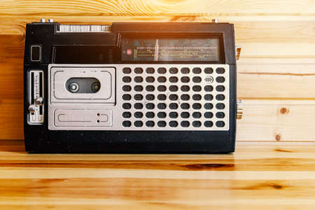 Retro oldschool design radio cassette tape recorder on wooden tableの写真素材