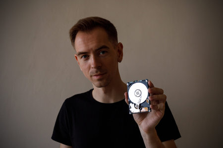 A man holding an HDD disk in his hand