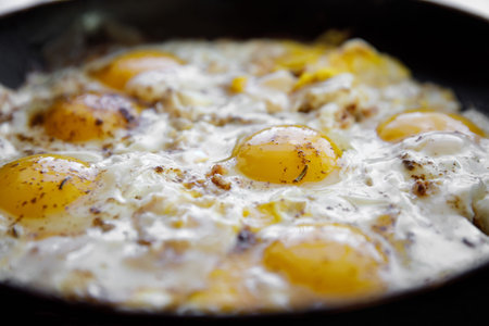 Scrambled eggs with spices are cooked in a skillet