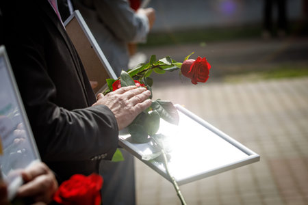Red rose and diploma in hands during the awarding ceremonyの写真素材
