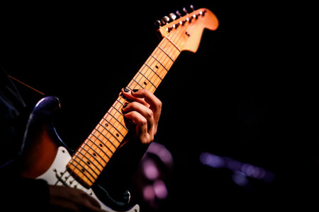 Hands on the guitar fretboard.