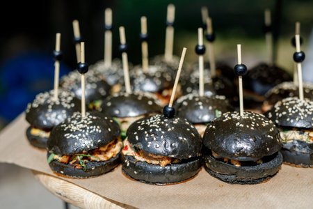 Close up of mini black fish burgers at catering eventの写真素材