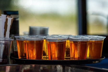 A lot of plastic beer glasses with a beer on a party, cold beerの写真素材