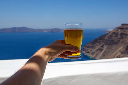 Cold beer glass on the blue sea background.の写真素材