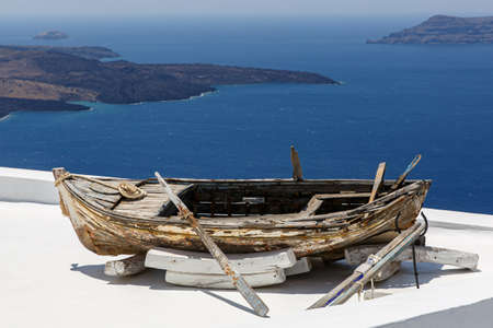 Historical boat on top of the roofs at Santorini island, Greeceの写真素材