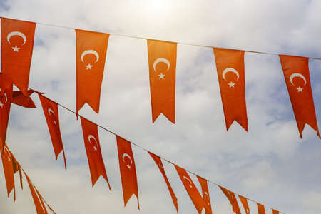 A row of waving flags of Turkey on the clouds backgroundの写真素材
