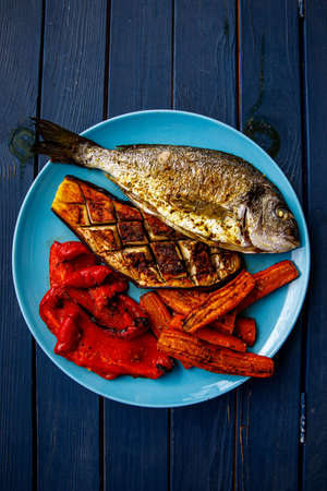 Fried dorado fish with vegetablesの写真素材