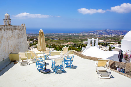 A sun terrace for rest with a wooden table and chairs in Thira, Santorini island, Greece.の写真素材