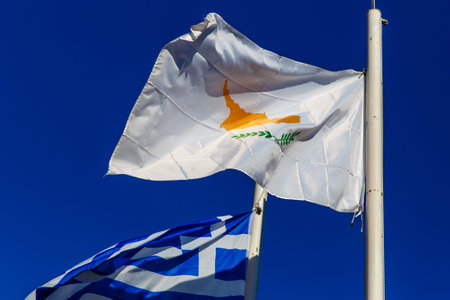 Flag of Cyprus next to the Greek fluttering against the sky