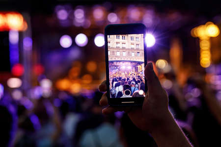 People holding their smartphones at concert and taking picturesの写真素材