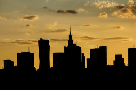 Silhouette of the city skyline during a beautiful sunset. Cityscape under the cloudsの写真素材