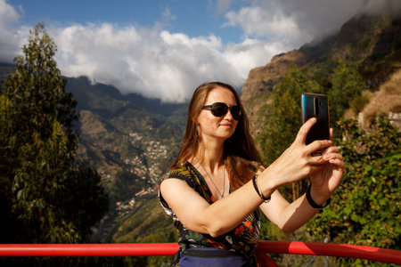 Beautiful girl with freckles making a selfie during a trip around Madeira islandの写真素材