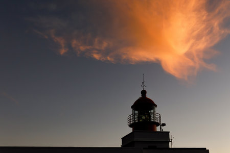 The classic lighthouse silhouette during the sunset, dramatic clouds in the skyの写真素材