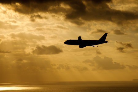 Airplane flies through orange dramatic clouds.の写真素材