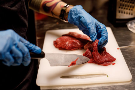 The chef cutting the raw meat