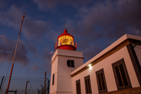 Ocean lighthouse during the sunset. Dramatic clouds on the backgroundの写真素材