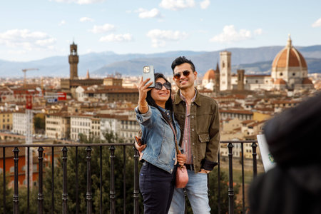 Florence, Italy - March 27, 2023: Asian couple taking a selfie against the background of Florence panorama.のeditorial素材