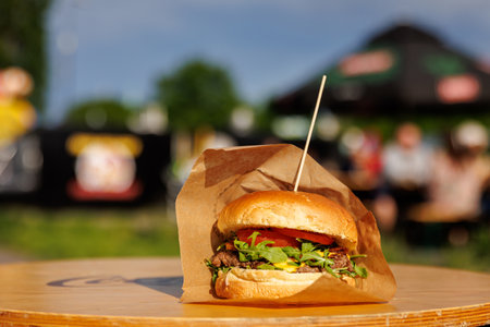 Fresh beef burger in a craft paper at the street food festivalの写真素材