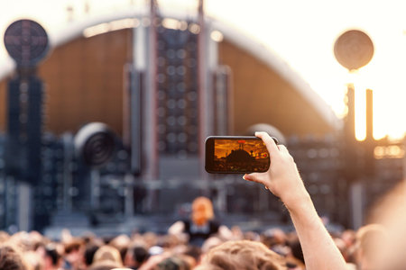 Smartphone in a Fan's Hand During an Outdoor Music Festival.