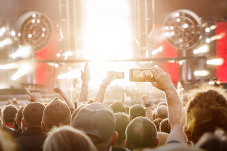 Smartphones in the Hands of the Crowd at an Outdoor Music Eventの写真素材
