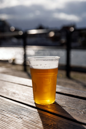 Cold beer in a plastic glass on the streets of a European city.の写真素材