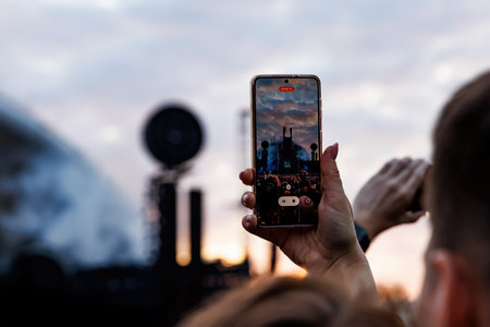 Smartphone in a Fan's Hand During an Outdoor Music Festival.の写真素材