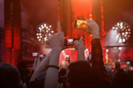 Smartphone in a Fan's Hand During an Outdoor Music Festival.