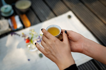 Tiny Chinese teacup in woman's hands during a tea ceremony